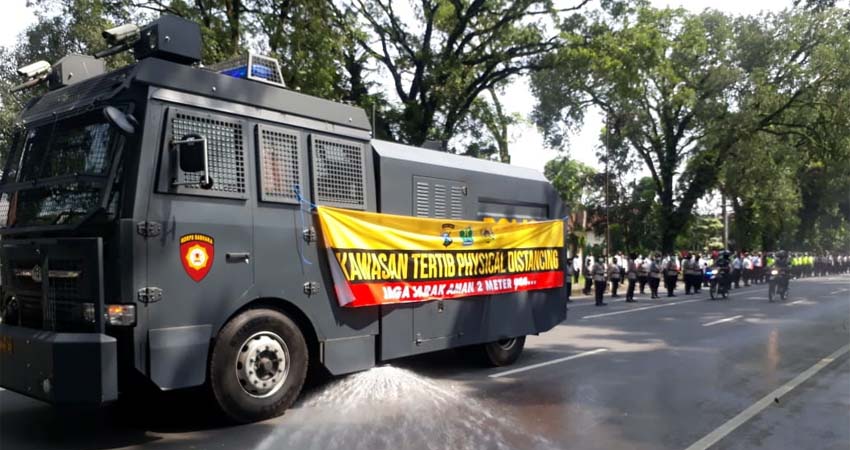 Kendaraan Water Canon Polresta Malang Kota digunakan untuk penyemprotan cairan Disinfektan di Jl Ijen. (gie)