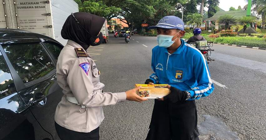 Sat Lantas Polresta Malang Kota bagikan nasi kotak dan masker saat sosialisasi Prokes. (ist)